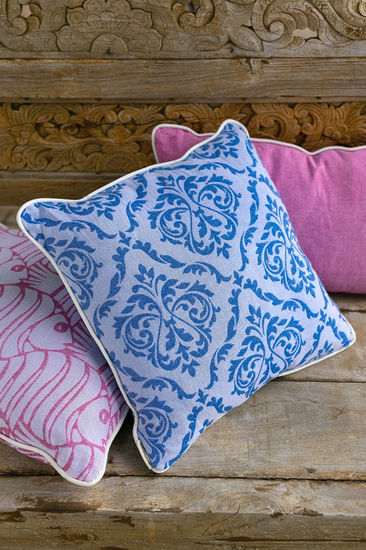 Blue throw pillow with damask pattern on front face