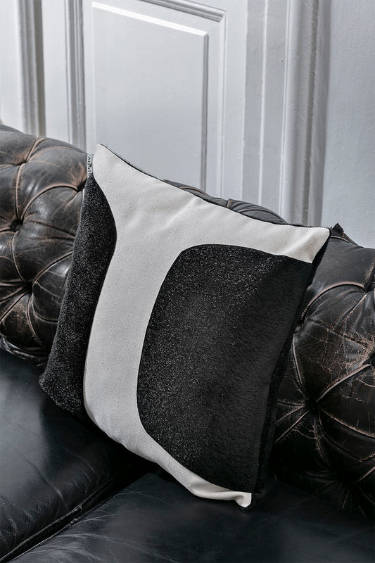 Black minimalistic throw pillow on black leather sofa