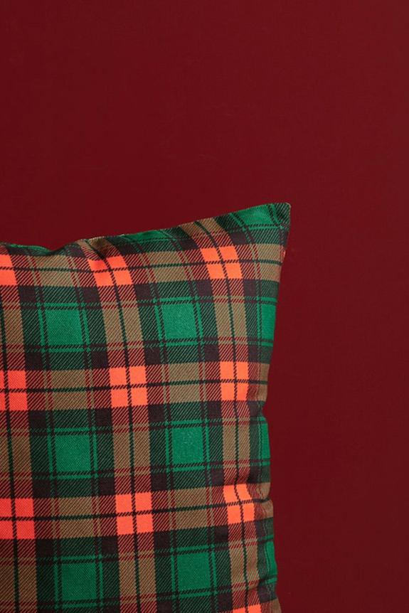 Close-up view of the red and green tartan plaid fabric texture on the handmade pillow cover